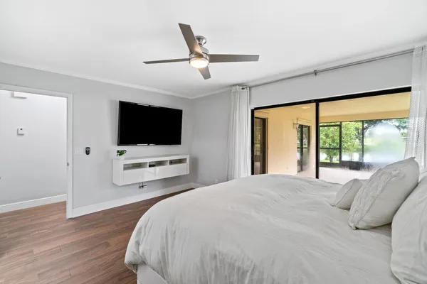 a bedroom with a bed tv and a large window