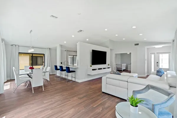 a living room with furniture flat screen tv and wooden floor