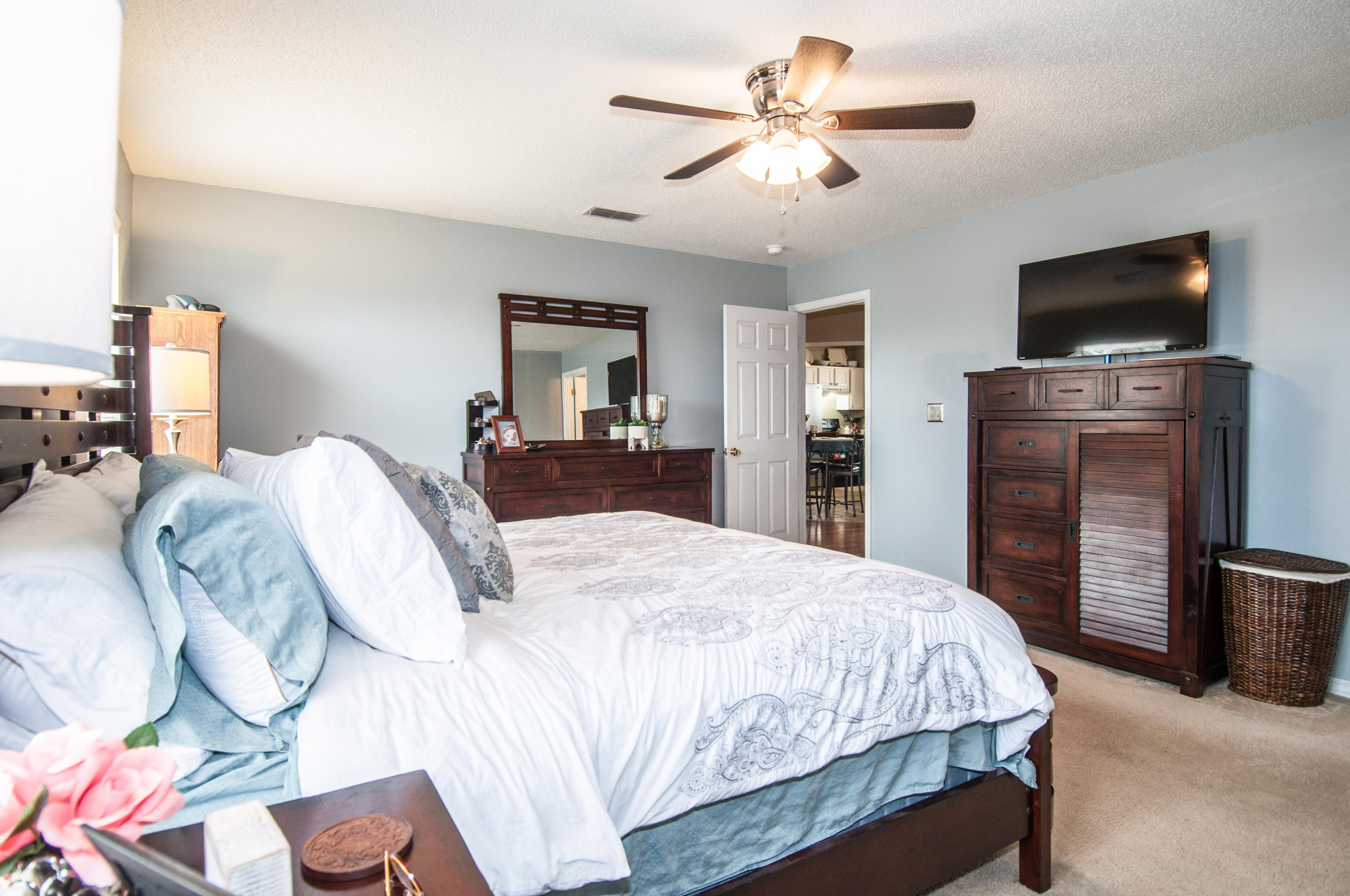 210 Limestone Circle Crestview, FL 32539 - Photo 44 of 54 a bedroom with a large bed a flat tv screen and dresser