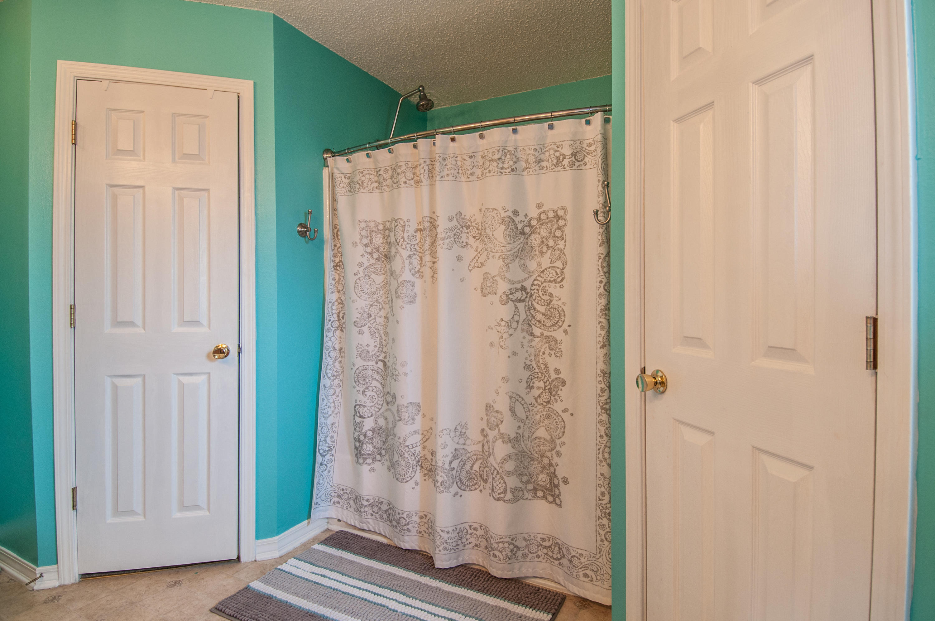 210 Limestone Circle Crestview, FL 32539 - Photo 47 of 54 a bathroom with a shower and a wooden door
