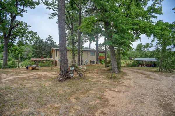 a view of a house with backyard and trees