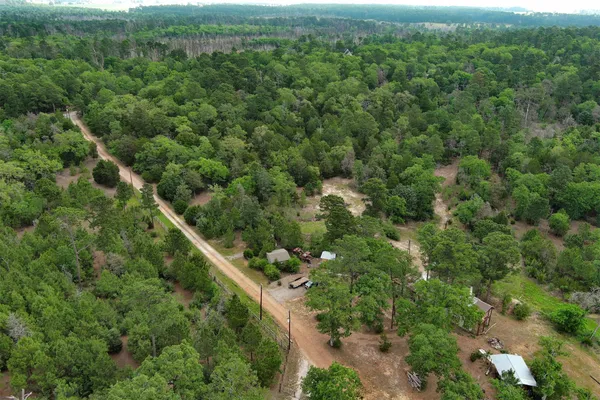 an aerial view of a house with a lush green forest