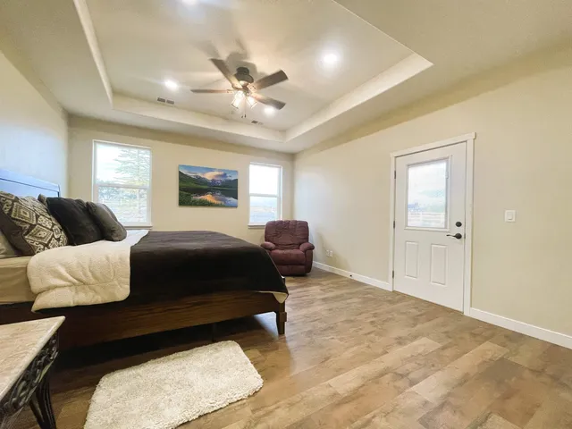 a spacious bedroom with a bed a couch and a chandelier