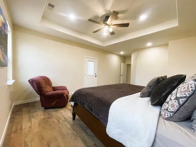 a spacious bedroom with a bed and cabinet