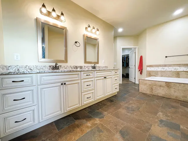 a bathroom with a tub sink and mirror