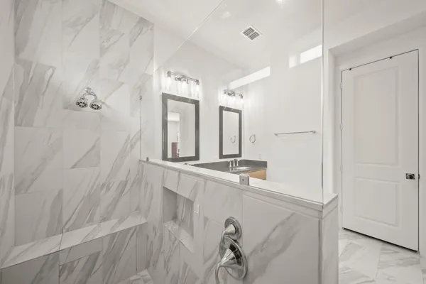 a bathroom with a granite countertop sink toilet and shower