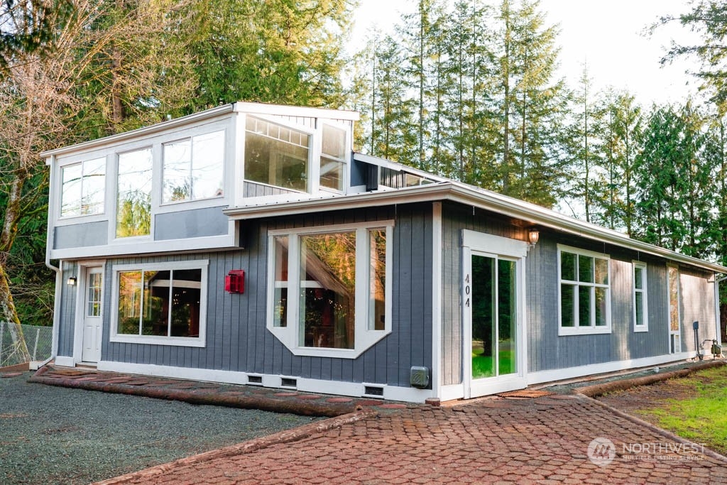 a view of a house with a yard and large tree