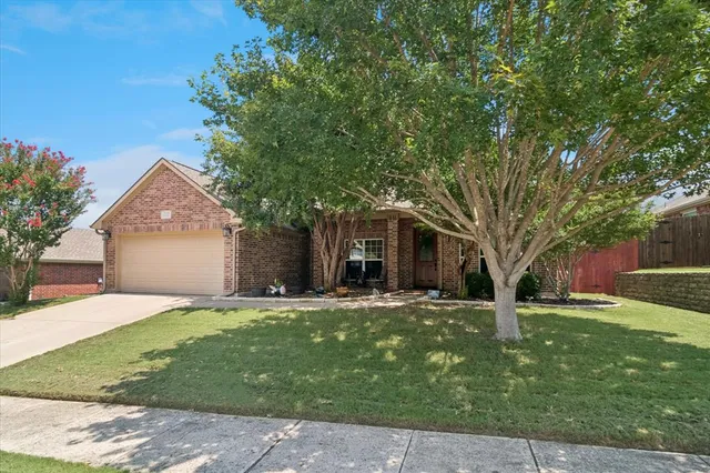 a front view of a house with a yard and trees