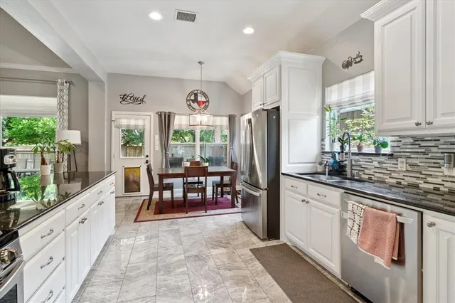 a kitchen with stainless steel appliances kitchen island granite countertop a stove refrigerator and a sink