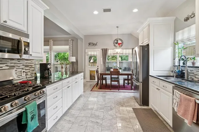 a kitchen with stainless steel appliances kitchen island granite countertop a stove a sink and a microwave