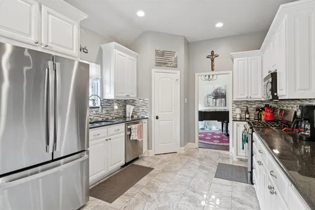 a kitchen with stainless steel appliances granite countertop a refrigerator and a stove top oven