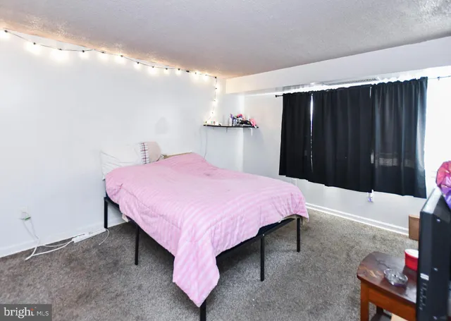 a spacious bedroom with a bed and a chandelier