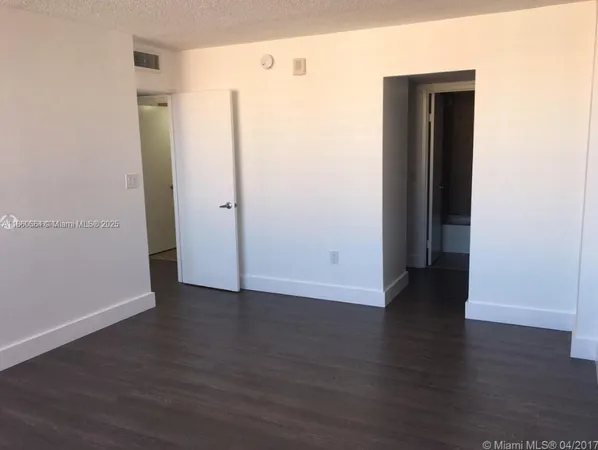 an empty room with wooden floor and closet