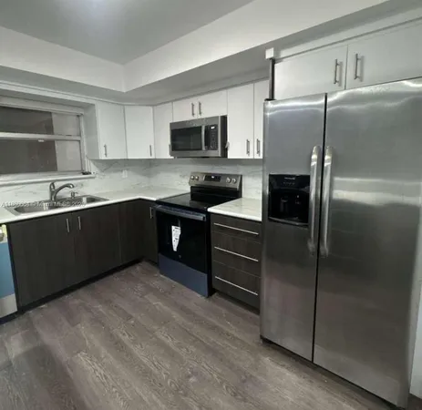 a kitchen with stainless steel appliances granite countertop a refrigerator and a sink
