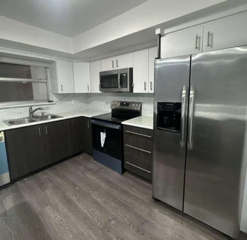 a kitchen with stainless steel appliances granite countertop a refrigerator and a sink