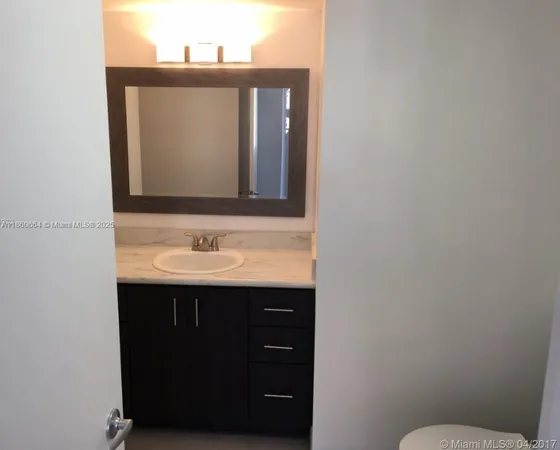 a bathroom with a sink vanity and a toilet