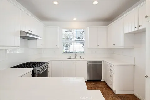 a kitchen with white cabinets and white appliances