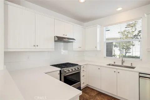 a kitchen with stainless steel appliances a sink stove and cabinets