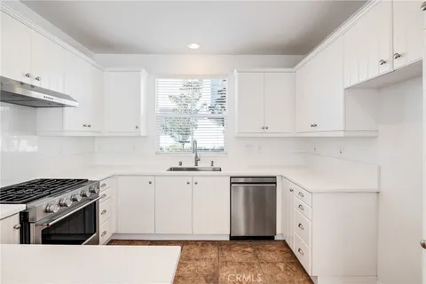 a kitchen with granite countertop a sink stove and cabinets