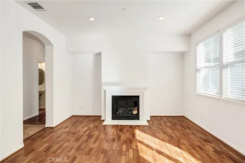 a view of empty room with wooden floor and fireplace