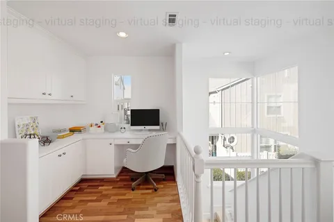 a view of a workspace with furniture and a window