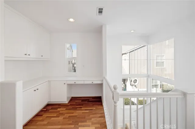 a view of utility room and bedroom with wooden floor