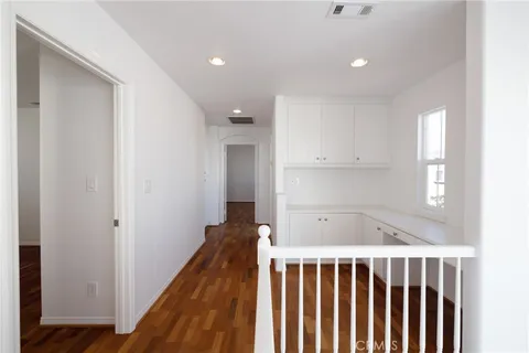a view of a hallway with wooden floor and staircase