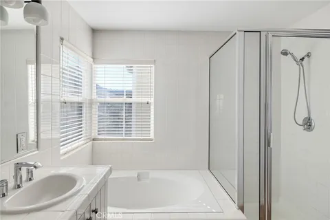 a bathroom with a granite countertop sink a mirror and a shower