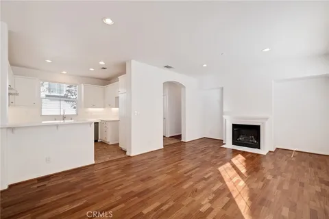 a view of empty room with wooden floor and fireplace