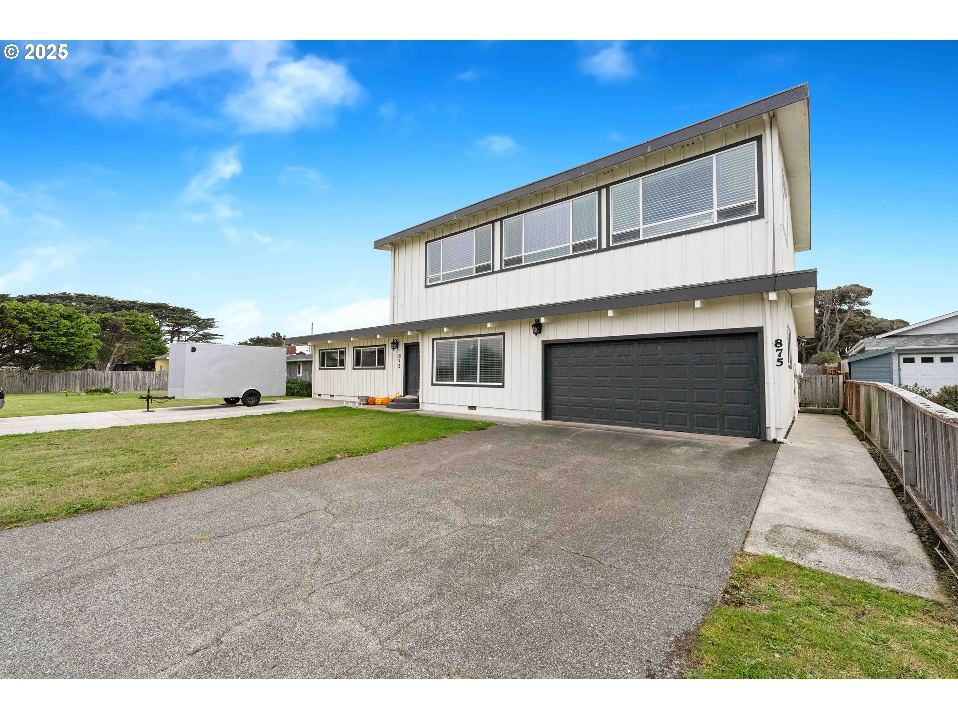 875 Ocean Drive Southwest Bandon, OR 97411 - Photo 2 of 31 a front view of a house with a yard and garage