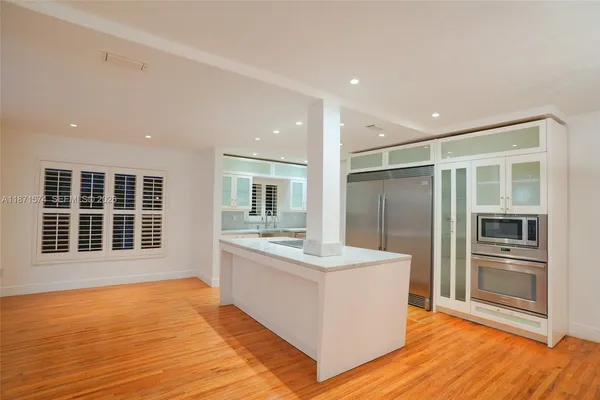 a view of empty room with wooden floor and fireplace