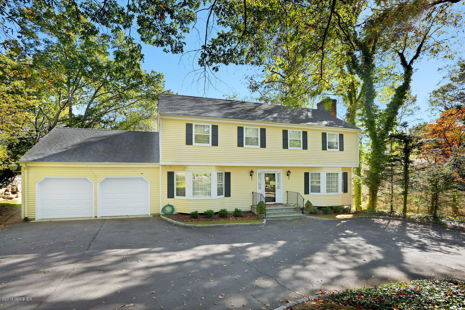 115 Stanwich Road Greenwich, CT 06830 - Photo 1 of 8 a view of a white house with large windows and a large tree