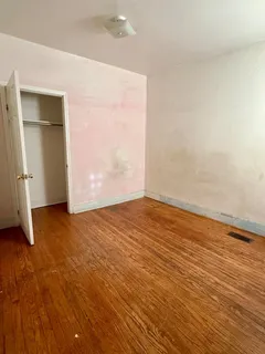 an empty room with wooden floor and closet