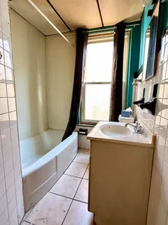 a bathroom with a tub sink and window