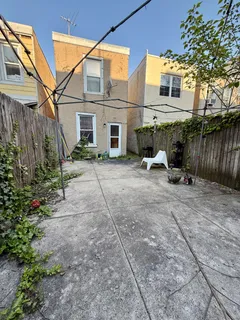 a view of backyard with a table and chairs under an umbrella