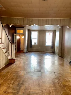a view of a hallway with wooden floor and windows
