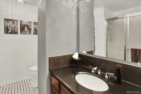 a bathroom with a sink a toilet a mirror and shower curtain