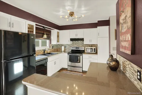 a kitchen with stainless steel appliances a stove a refrigerator and a sink