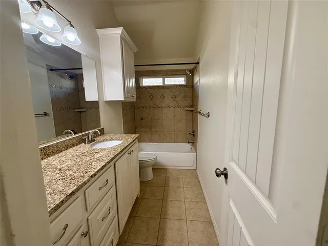 a bathroom with a granite countertop sink a toilet and shower