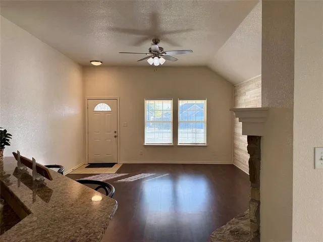 a view of a livingroom with wooden floor and a ceiling fan