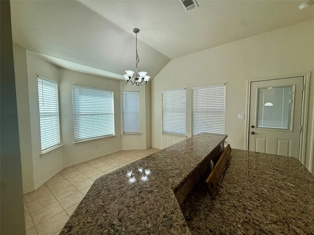 a spacious bedroom with a bed and a chandelier