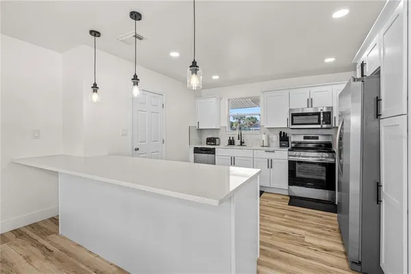 a kitchen with cabinets stainless steel appliances and a counter space