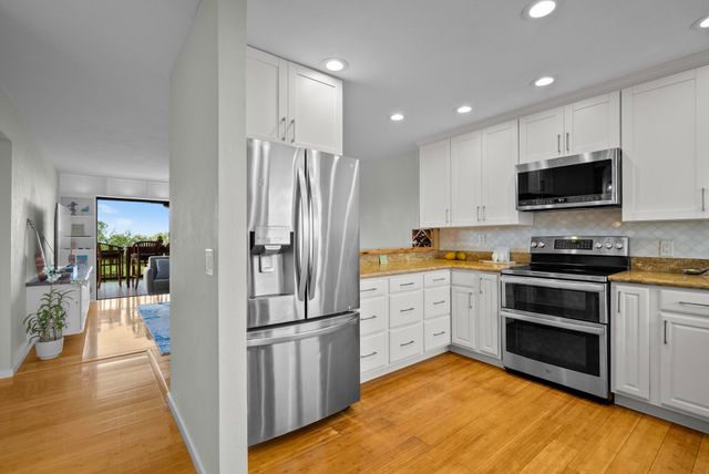 a kitchen with a refrigerator and a stove top oven
