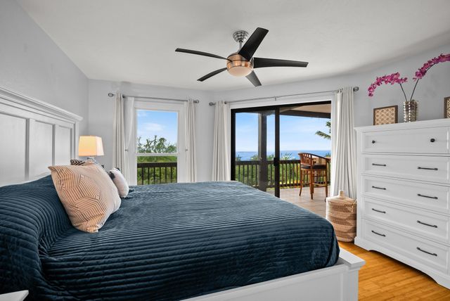 a bedroom with a bed a dresser and a large window