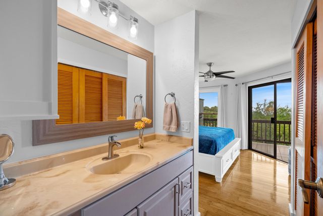 a bathroom with a granite countertop sink and a large mirror