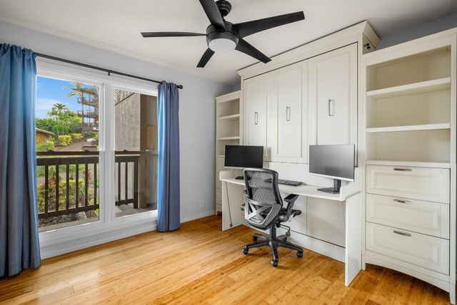 a view of a workspace with furniture and a window