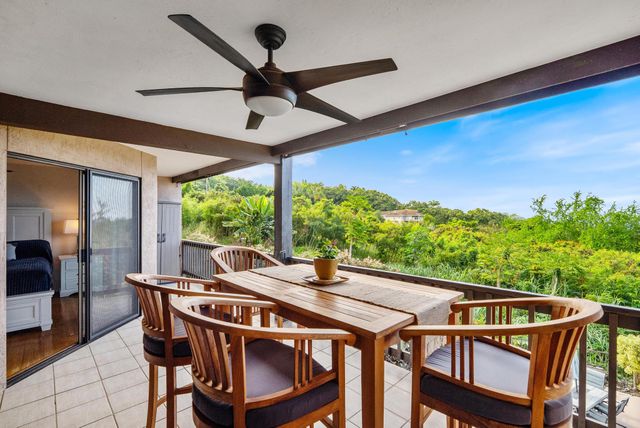 a view of a patio with a table chairs and a floor to ceiling window