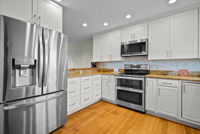 a kitchen with stainless steel appliances a refrigerator sink and microwave