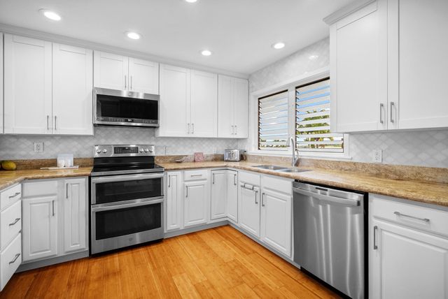 a kitchen with granite countertop a sink and cabinets
