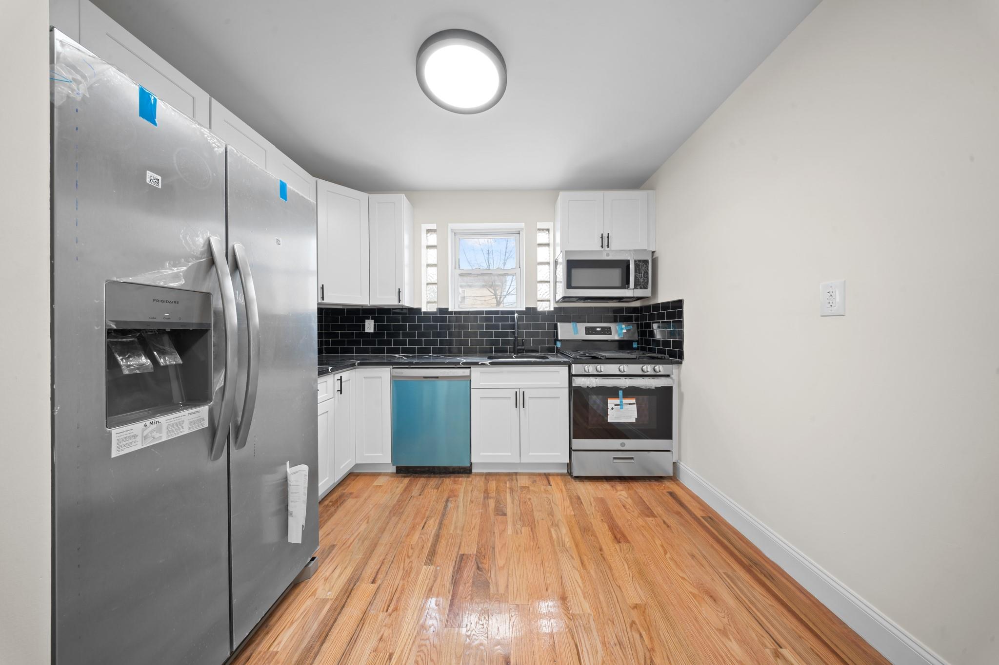 179-20 Anderson Road Queens, NY 11434 - Photo 1 of 1 Kitchen with decorative backsplash, white cabinetry, stainless steel appliances, and dark countertops